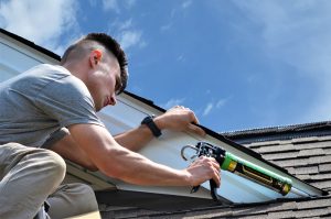 Caulking A Roof To Keep Bats Out - Pictured here is Alex who is a bat removal and bat exclusion expert at the Cottom's Wildlife Removal company in Ohio.